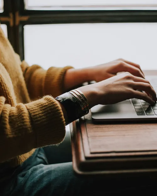 A person studying at a laptop with notes