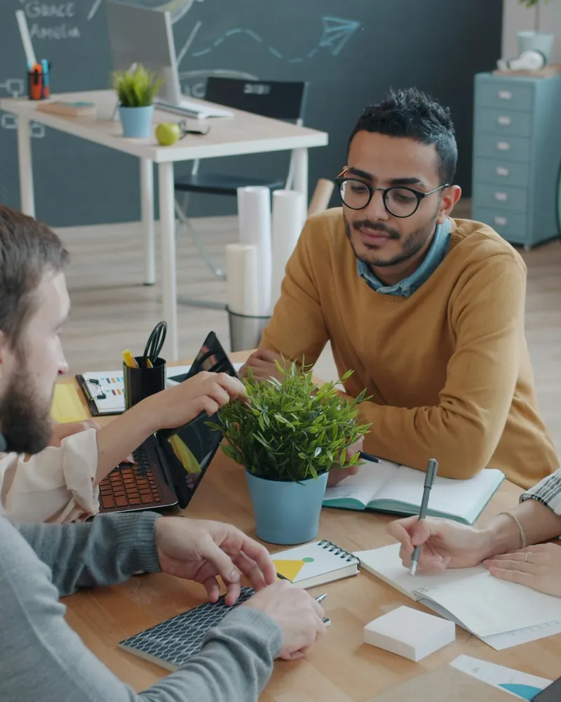 A diverse team collaborating around a table in a bright office
